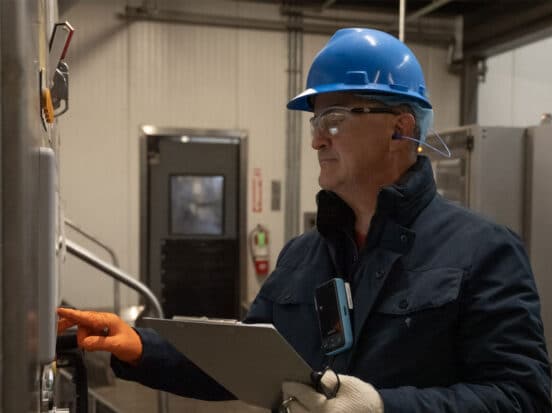 Cover image for a blog on industrial digital transformation 101 featuring a worker in an industrial environment.