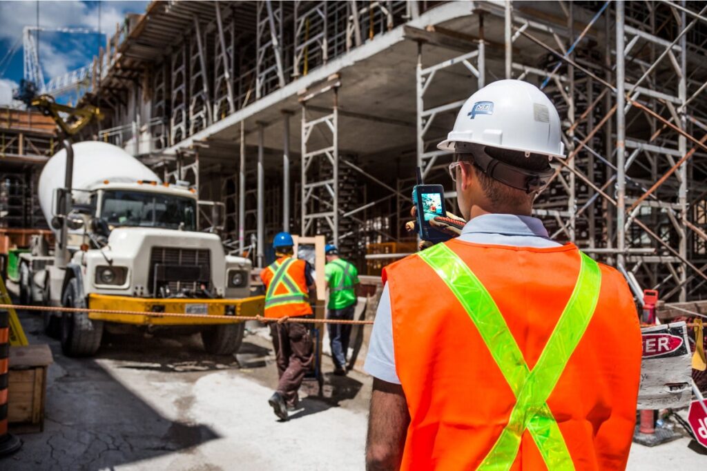 Construction worker using a walt smart radio to take a picture