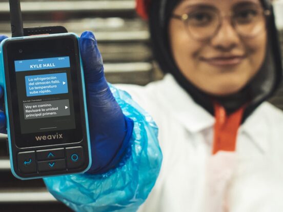Thumbnail for a blog post on AI translation shows a manufacturing worker holding a Walt Smart Radio, which integrates real-time AI language translation capabilities.