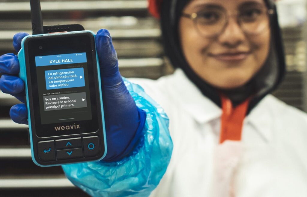 Frontline worker holding up a Walt Smart Radio by weavix