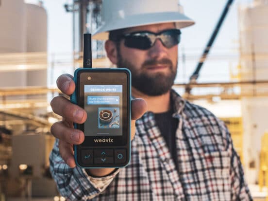 Frontline worker holding up a Walt Smart Radio by weavix
