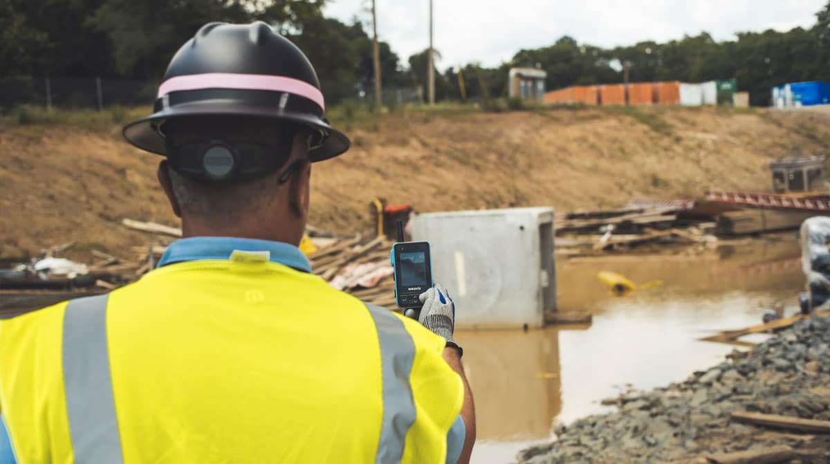 Construction worker taking a picture using a Walt Smart Radio