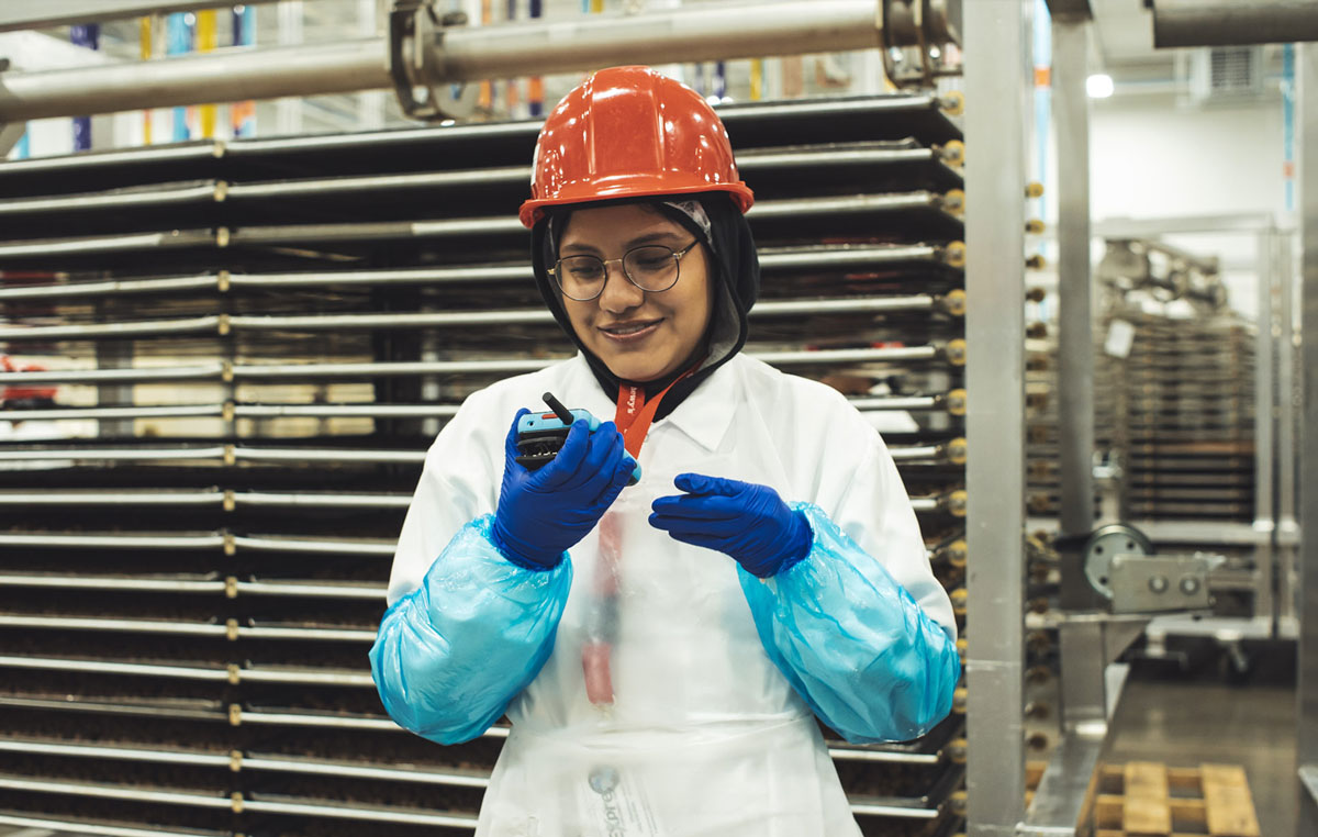 Manufacturing worker using a Walt Smart Radio by weavix to communicate