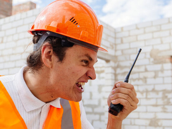 Construction worker shouting at a walkie talkie