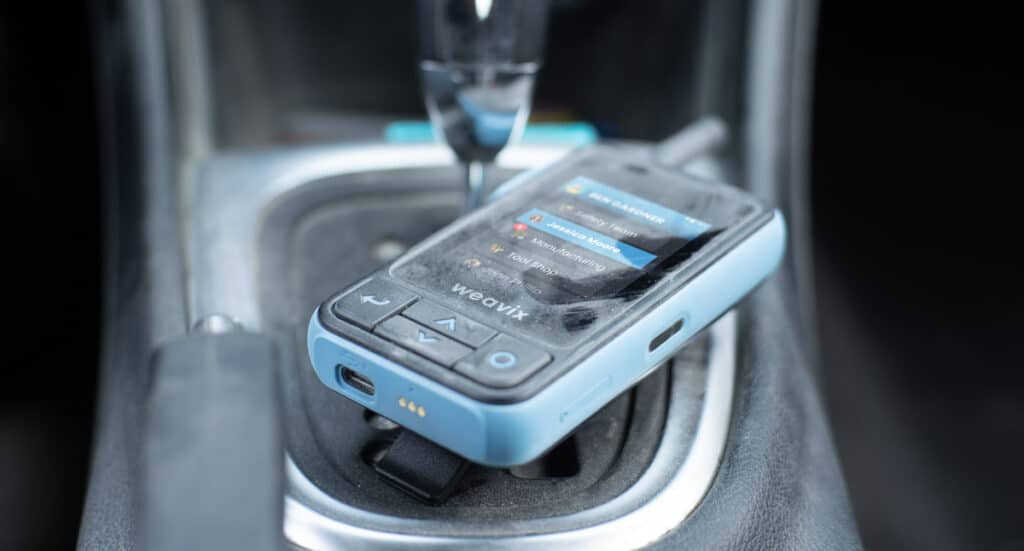 weavix Walt Smart Radio with IP68 certification being used in a harsh industrial environment with water and dust protection.