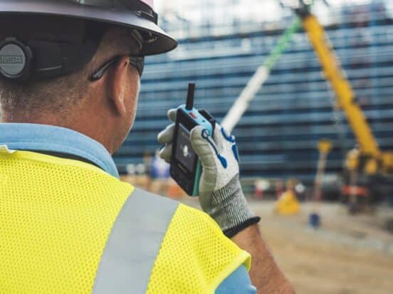 Construction worker using the push-to-talk feature on the Walt Smart Radio